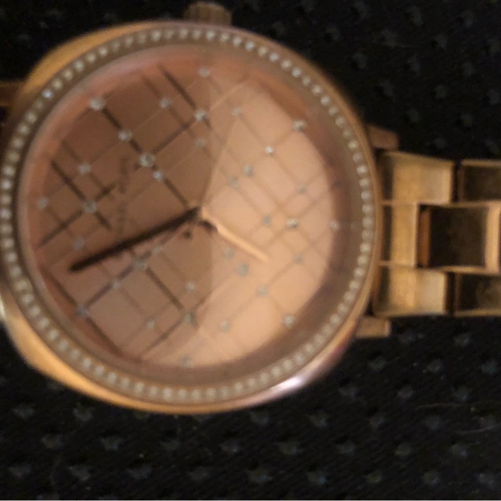 Michael Kors rose gold watch with rhinestone embellishments.